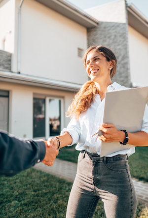person-signing-papers-in-front-yard-of-home.jpg