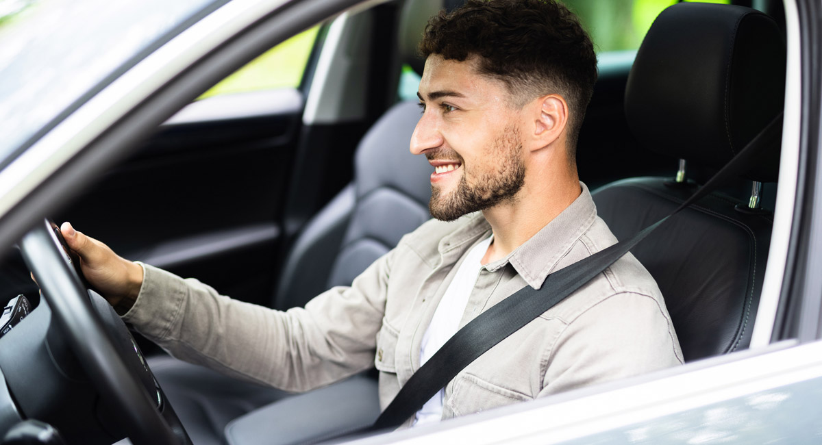 Smiling-man-driving-car-with-seatbelt-on