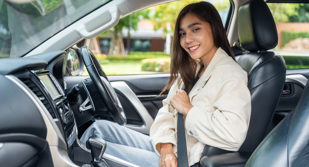 Woman fastening seatbelt in driver seat