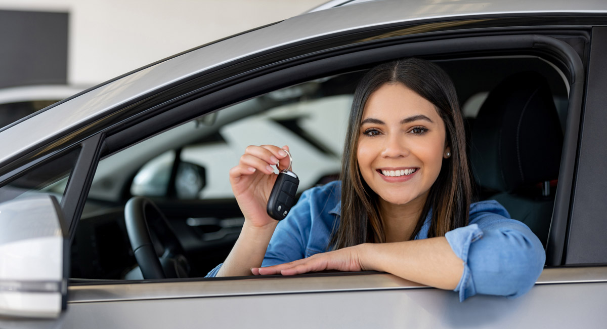 Woman in car smiling and holding keys