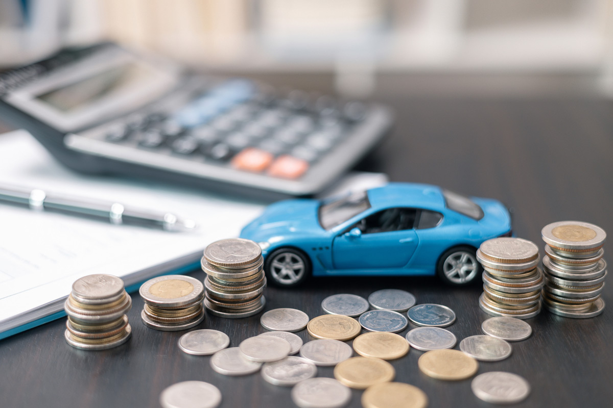 blue-toy-car-on-desk-with-coins,-calculator