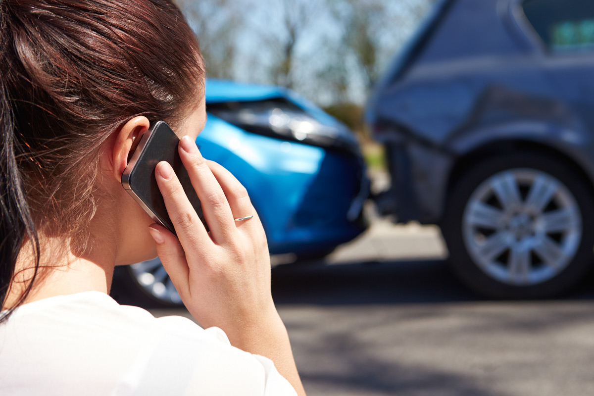 woman-on-phone-next-to-rear-end-accident-scene