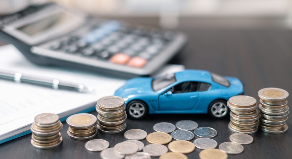 blue-toy-car-on-desk-with-coins,-calculator