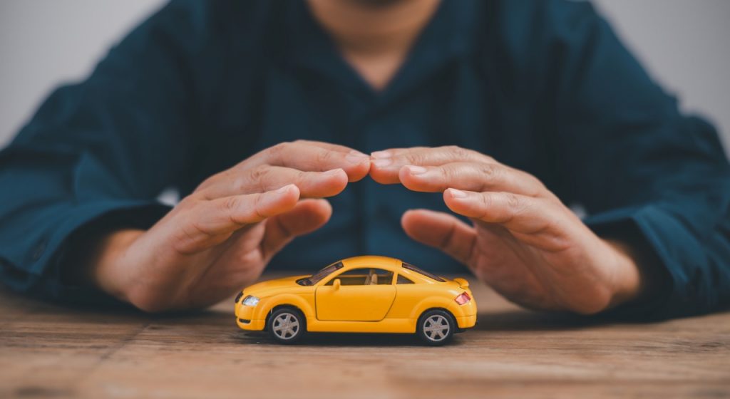 Hand protecting a yellow toy car