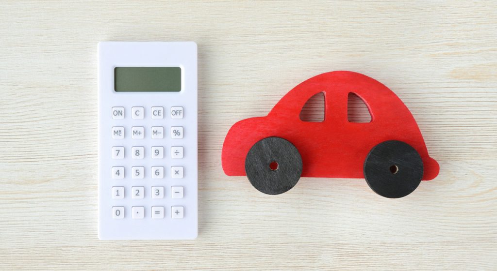 white-calculator-by-red-toy-car-on-table