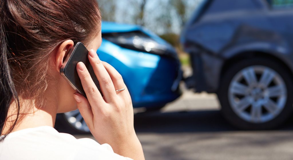 woman-on-phone-next-to-rear-end-accident-scene