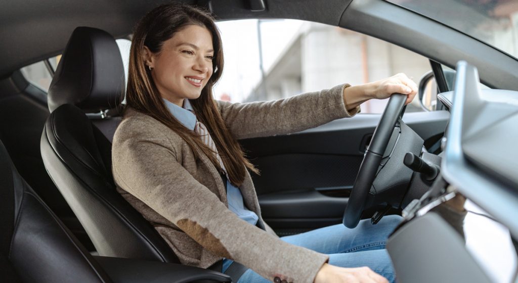 woman-smiling-in-driver's-seat-of-car
