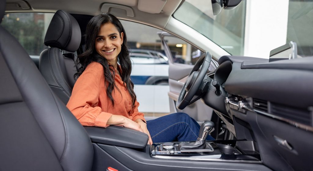 woman-smiling-in-front-seat-of-parked-car
